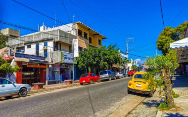 Puerto Escondido Oaxaca Meksika 16. Ocak 2023 Tipik güzel turist caddesi yolu ve şehir arabalarıyla kaldırım oteller, restoranlar ve Zicatela Mexico 'daki insanlar..