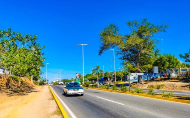 Puerto Escondido Oaxaca Meksika 27. Ocak 2023 Tipik güzel turist caddesi yolu ve şehir arabalarıyla kaldırım oteller, restoranlar ve Zicatela Mexico 'daki insanlar..