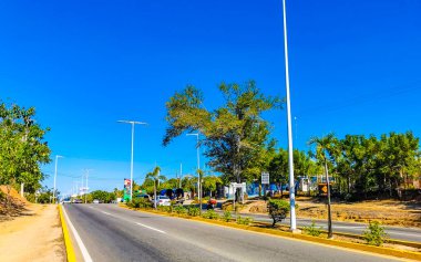 Puerto Escondido Oaxaca Meksika 27. Ocak 2023 Tipik güzel turist caddesi yolu ve şehir arabalarıyla kaldırım oteller, restoranlar ve Zicatela Mexico 'daki insanlar..