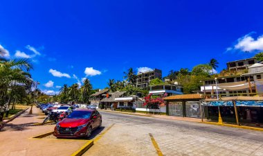Puerto Escondido Oaxaca Meksika 24. Mart 2023 Tipik güzel turistik cadde yolu ve şehir arabalarıyla kaldırım oteller, restoranlar ve Zicatela Mexico 'daki insanlar..