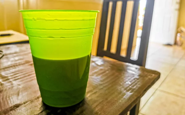 クリーンなキッチンで木製の背景にメキシコから黒コーヒーの緑のプラスチックガラスカップ — ストック写真