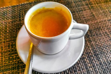 Glass cup of americano black coffee with spoon and plate on table food and drink in the restaurant PapaCharly Papa Charly in Playa del Carmen Quintana Roo Mexico.