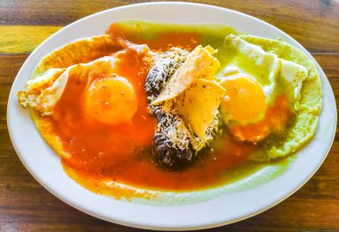 Meksika huevos omleti siyah fasulyeli yumurta patates ve Zicatela Puerto Oaxaca Meksika 'da yeşil ve kırmızı soslu cips..