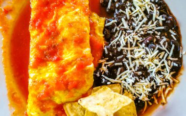 Meksika omleti ve siyah fasulyeli yumurta patates ve beyaz tabakta nachos Zicatela Puerto Oaxaca Meksika 'da El Cafecito' da..