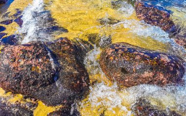 Plaj kumsalı turkuvaz mavi su kayaları kaya kayaları palmiye ağaçları büyük sörfçü dalgaları ve plaj manzarası Playa Manzanillo ve Puerto Angelito Puerto Escondido Oaxaca Meksika.
