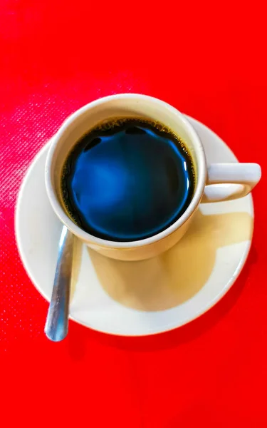 Tazza Caffè Americano Nero Con Cucchiaio Piatto Tavola Rossa Sfondo — Foto Stock