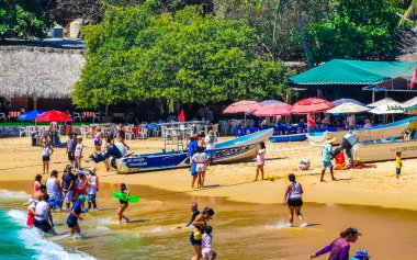 Puerto Escondido Oaxaca Meksika 25. Mart 2023 Palmiye ağaçları insanlar Zicatela Puerto Escondido Oaxaca Meksika 'daki tropikal Meksika plajında şemsiye ve güneş panzeleri tekneleri.
