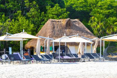 Playa del Carmen Meksika 'daki tropik Meksika plajındaki sahil otelindeki şemsiyeler ve güneş panzeleri..