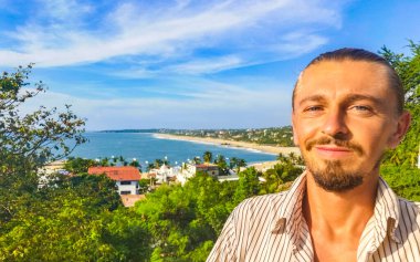 Erkek turist güzel kayalıklarla selfie çekiyor kayalar kayalar kayalar, büyük sörfçü dalgaları ve Puerto Escondido Oaxaca 'da doğal manzara..