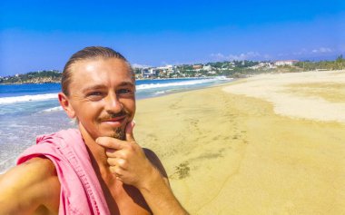 Erkek turist güzel kayalıklarla selfie çekiyor kayalar kayalar kayalar, büyük sörfçü dalgaları ve Puerto Escondido Oaxaca 'da doğal manzara..