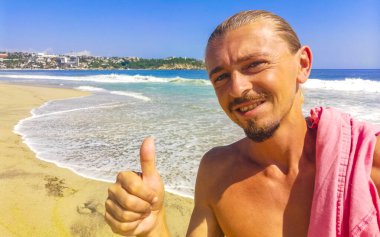 Erkek turist güzel kayalıklarla selfie çekiyor kayalar kayalar kayalar, büyük sörfçü dalgaları ve Puerto Escondido Oaxaca 'da doğal manzara..