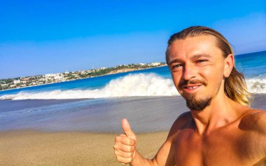 Erkek turist güzel kayalıklarla selfie çekiyor kayalar kayalar kayalar, büyük sörfçü dalgaları ve Puerto Escondido Oaxaca 'da doğal manzara..