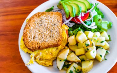 Yumurtalı tost soğanlı avokado salatası ve beyaz tabakta patates Zicatela Puerto Escondido Oaxaca Meksika 'da..