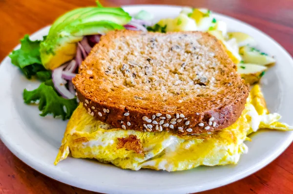 Yumurtalı tost soğanlı avokado salatası ve beyaz tabakta patates Zicatela Puerto Escondido Oaxaca Meksika 'da..