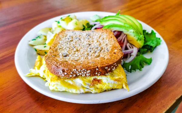 Yumurtalı tost soğanlı avokado salatası ve beyaz tabakta patates Zicatela Puerto Escondido Oaxaca Meksika 'da..