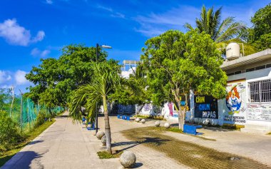 Playa del Carmen Quintana Roo Meksika 6. Mayıs 2023 Tipik yaya yolu ve şehir manzarası Palmiye ağaçlarıyla banklar mimari binalar ve Luis Donaldo Colosio 'nun duvar resimleri.