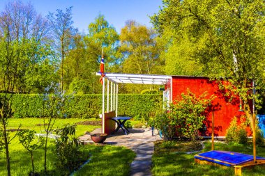 Green garden with beautiful red garden house in norwegian style in Leherheide Bremerhaven Bremen Germany.