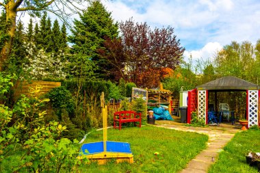 Green garden with beautiful red garden house in norwegian style in Leherheide Bremerhaven Bremen Germany.