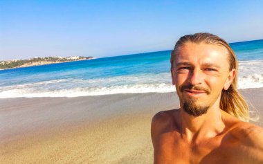 Erkek turist güzel kayalıklarla selfie çekiyor kayalar kayalar kayalar, büyük sörfçü dalgaları ve Puerto Escondido Oaxaca 'da doğal manzara..