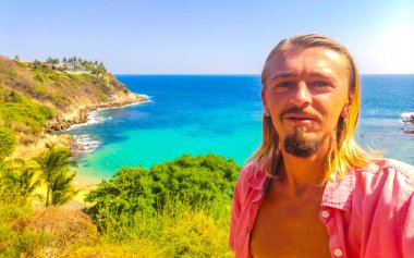 Erkek turist güzel kayalıklarla selfie çeker kaya kayaları, dev sörfçü dalgaları ve Puerto Escondido Oaxaca 'daki Carrizalillo plajında doğal manzara..