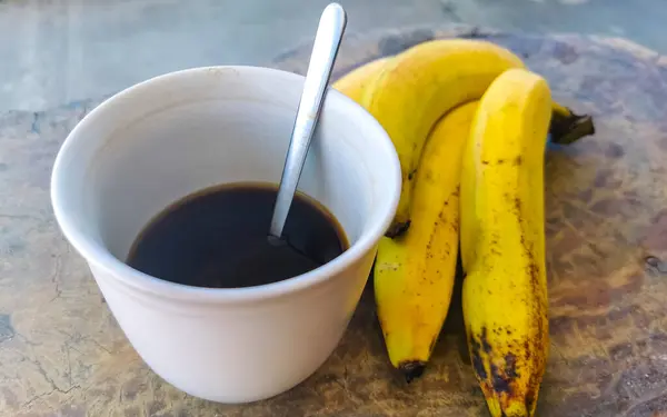 Filiżanka Americano Czarna Kawa Łyżką Talerzem Stole Jedzenie Picie Bananami — Zdjęcie stockowe