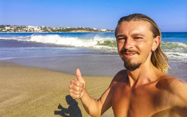 Erkek turist güzel kayalıklarla selfie çekiyor kayalar kayalar kayalar, büyük sörfçü dalgaları ve Puerto Escondido Oaxaca 'da doğal manzara..