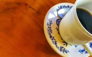 Zicatela Puerto Escondido Mexico 'daki El Cafecito' daki ahşap masada siyah kahve fincanı..