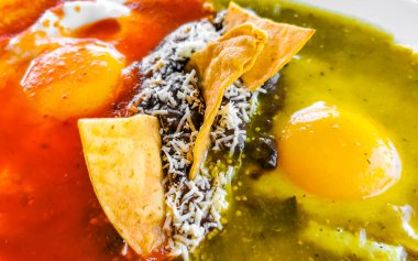 Meksika huevos omleti siyah fasulyeli yumurta patates ve Zicatela Puerto Oaxaca Meksika 'da yeşil ve kırmızı soslu cips..