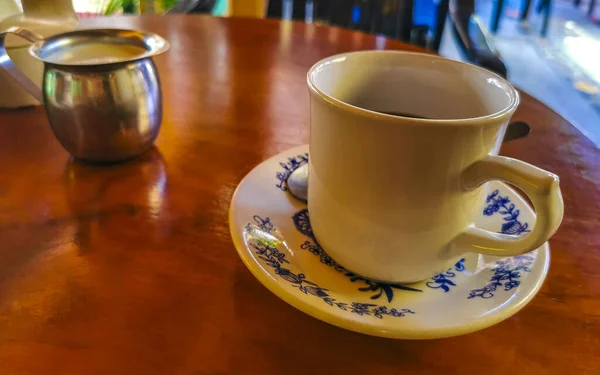 Zicatela Puerto Escondido Mexico的El Cafecito的木制桌子上放着蓝白相间的咖啡壶 上面有美国式的黑咖啡 — 图库照片