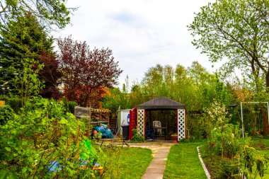 Green garden with beautiful red garden house in norwegian style in Leherheide Bremerhaven Bremen Germany.