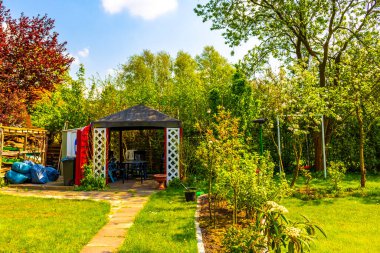 Green garden with beautiful red garden house in norwegian style in Leherheide Bremerhaven Bremen Germany.