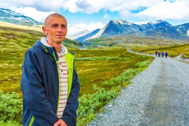 Genç yürüyüşçü ve güzel yaz manzarası dağları, nehir kayaları ve İskandinavya 'daki Ringbu Innlandet Norveç' teki Rondane Ulusal Parkı 'nın yürüyüş yolu..