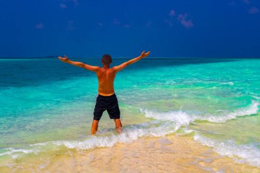 Erkek model ve turist, Rasdhoo Mercan Maldivleri 'ndeki Madivaru ve Finolhu adalarının kumsalında tatilde eğleniyor ve güzel poz veriyor..