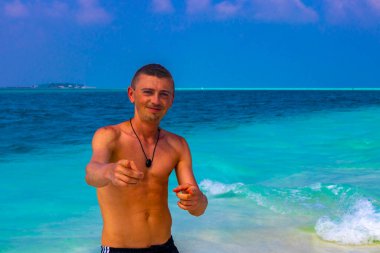Erkek model ve turist, Rasdhoo Mercan Maldivleri 'ndeki Madivaru ve Finolhu adalarının kumsalında tatilde eğleniyor ve güzel poz veriyor..
