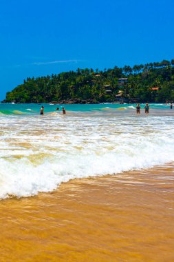 Mirissa Sahili 'nin güneyindeki Sri Lanka Plajı' nda palmiye ağaçları dalgaları ve deniz manzaralı güzel tropik bir sahil..