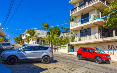 Puerto Escondido Oaxaca Meksika 01. Şubat 2023 Tipik güzel turistik cadde yolu ve şehir arabalarıyla kaldırım oteller, restoranlar ve Zicatela Mexico 'daki insanlar..
