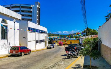 Puerto Escondido Oaxaca Meksika 15. Şubat 2023 Tipik güzel turistik cadde yolu ve şehir arabalarıyla kaldırım oteller, restoranlar ve Zicatela Mexico 'daki insanlar..