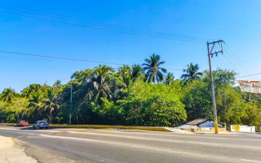 Puerto Escondido Oaxaca Meksika 24. Mart 2023 Tipik güzel turistik cadde yolu ve şehir arabalarıyla kaldırım oteller, restoranlar ve Zicatela Mexico 'daki insanlar..