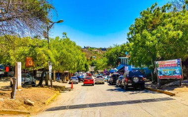 Puerto Escondido Oaxaca Meksika 25. Mart 2023 Tipik güzel turistik cadde yolu ve şehir arabalarıyla kaldırım oteller, restoranlar ve Zicatela Mexico 'daki insanlar..