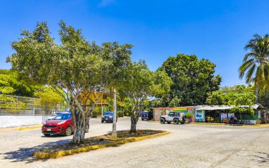 Puerto Escondido Oaxaca Meksika 29. Mart 2023 Tipik güzel turistik cadde yolu ve şehir arabalarıyla kaldırım oteller, restoranlar ve Zicatela Mexico 'daki insanlar..