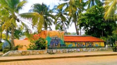 Puerto Escondido Oaxaca Meksika 12. Ekim 2022 Tipik güzel turistik cadde yolu ve şehir arabalarıyla kaldırım oteller, restoranlar ve Zicatela Mexico 'daki insanlar..