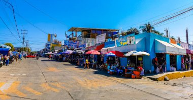 Puerto Escondido Oaxaca Meksika 16. Ocak 2023 Tipik güzel turist caddesi yolu ve şehir arabalarıyla kaldırım oteller, restoranlar ve Zicatela Mexico 'daki insanlar..