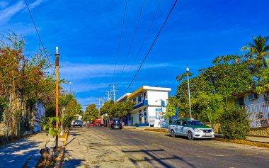 Puerto Escondido Oaxaca Meksika 20. Ocak 2023 Tipik güzel turist caddesi yolu ve şehir arabalarıyla kaldırım oteller, restoranlar ve Zicatela Mexico 'daki insanlar..