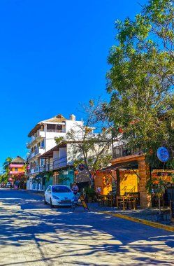 Puerto Escondido Oaxaca Meksika 27. Ocak 2023 Tipik güzel turist caddesi yolu ve şehir arabalarıyla kaldırım oteller, restoranlar ve Zicatela Mexico 'daki insanlar..