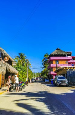 Puerto Escondido Oaxaca Meksika 27. Ocak 2023 Tipik güzel turist caddesi yolu ve şehir arabalarıyla kaldırım oteller, restoranlar ve Zicatela Mexico 'daki insanlar..