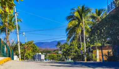 Puerto Escondido Oaxaca Meksika 27. Ocak 2023 Tipik güzel turist caddesi yolu ve şehir arabalarıyla kaldırım oteller, restoranlar ve Zicatela Mexico 'daki insanlar..
