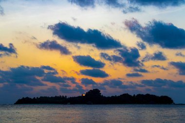 Tropik cennet adası Kuramathi. Palmiye ağaçları, turkuaz sular ve Rasdhoo Atoll Maldivleri 'nde muhteşem altın renkli günbatımı olan lüks bir tatil için..