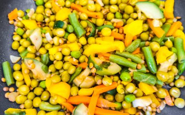 Vegetable dish soup with beans peas potatoes onions tomato and garlic on a white plate bowl with fork or spoon in Mexico.