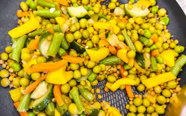 Vegetable dish soup with beans peas potatoes onions tomato and garlic on a white plate bowl with fork or spoon in Mexico.