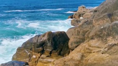 Plaj kumsalı turkuvaz mavi su kayaları kaya kayaları palmiye ağaçları büyük sörfçü dalgaları ve plaj manzarası Playa Manzanillo ve Puerto Angelito Puerto Escondido Oaxaca Meksika.